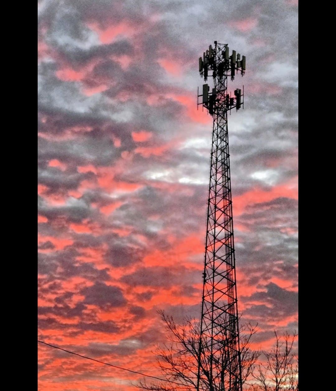 A communications tower against a red and gray West Texas evening sky